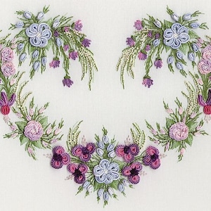 May include: Embroidered floral design in shades of purple, pink, and green, forming a heart shape. The design features various types of flowers and leaves, creating a delicate and intricate pattern.