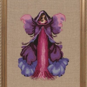 May include: A purple and pink cross-stitch embroidery of a fairy with wings and a long flowing gown.