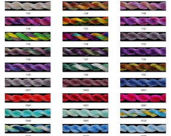 May include: A color chart of embroidery floss with a variety of colors, including gray, purple, green, red, blue, and pink. The floss is arranged in rows and columns, with each color labeled with a number.
