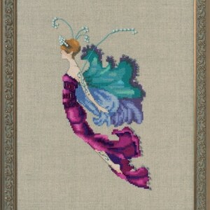 May include: A cross-stitch embroidery of a fairy with iridescent wings and a flowing purple dress. The fairy is surrounded by delicate white flowers.