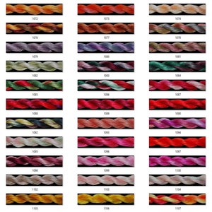 May include: A color chart of embroidery floss with 18 different colors. The floss is arranged in rows of three, with each row containing six different colors. The colors range from light to dark, and include shades of red, orange, yellow, green, blue, purple, and pink.