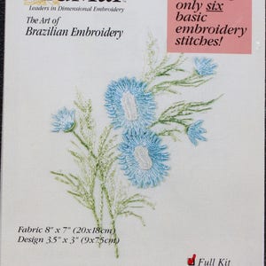 May include: A close-up of a craft embroidery pattern featuring a knotted lazy daisy design. The pattern is for a blue flower with green stems and leaves. The pattern is 3.5 inches by 3 inches and the fabric is 8 inches by 7 inches. The pattern is called "#5107 Knotted Lazy Daisy" and is made by EdMar Co. The pattern is available as a full kit or fabric only.
