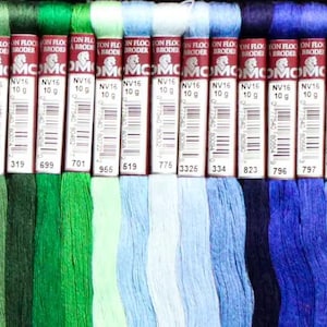 May include: A collection of DMC embroidery floss spools in various shades of green, blue, and white. The spools are labeled with the DMC number and the weight of the floss.