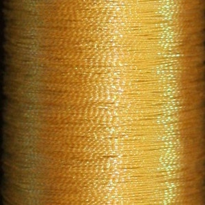 May include: Close-up of a spool of golden-yellow thread. The thread is tightly wound, showing a textured surface with vertical lines. The color is a warm, rich yellow, suggesting a high-quality material for sewing or embroidery.
