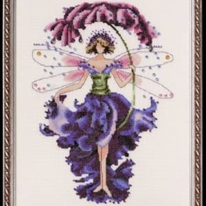 May include: Cross-stitch artwork of a fairy with a flower-petal dress and wings. The fairy has a purple flower headdress and holds a green stem. The artwork is framed in a brown, ornate frame.