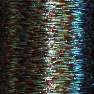 May include: A close-up of a spool of iridescent blue, green, and red beads. The beads are small and have a metallic sheen.