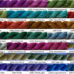 Puede incluir: Una colección de 20 ovillos de hilo en varios colores, incluyendo morado, verde, azul, rojo, naranja, marrón y amarillo. Cada ovillo está etiquetado con un número y un nombre de color.