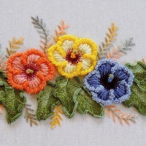 May include: Embroidered floral design featuring three flowers with yellow, orange, and blue petals. The flowers are surrounded by green leaves and stems.