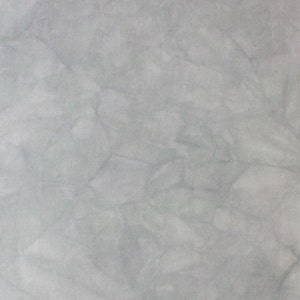 May include: A close-up of a light gray, textured surface with a subtle marbled pattern.