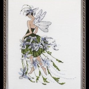 May include: A cross stitch pattern featuring a fairy with white wings and a green dress made of flowers. The fairy is wearing a white hat with a feather.