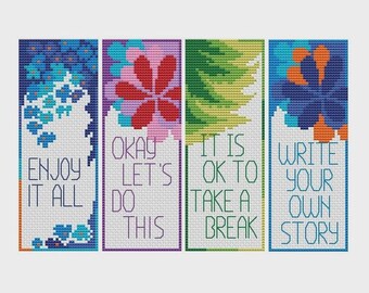 Könnte beinhalten: Vier Kreuzstich-Lesezeichen mit floralen Designs und inspirierenden Zitaten. Das erste Lesezeichen sagt "ENJOY IT ALL" mit blauen Blumen. Das zweite sagt "OKAY LET'S DO THIS" mit einer roten Blume. Das dritte sagt "IT IS OK TO TAKE A BREAK" mit grünen Blättern. Das vierte sagt "WRITE YOUR OWN STORY" mit blauen und orangen Blumen.