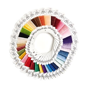 May include: A fan-shaped color chart of embroidery floss with a variety of colors, including red, blue, green, yellow, and purple. The floss is arranged in a circle with the brand name "R.G." printed on each card.