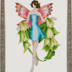 Könnte beinhalten: Eine Kreuzstich-Stickerei einer Fee mit rosa Flügeln und einem blauen Kleid. Die Fee ist von grünen Blättern und weißen Blumen umgeben.