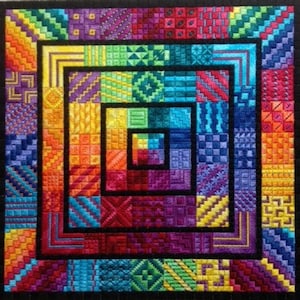 May include: A colorful square quilt with a concentric pattern of squares in various colors and textures. The quilt is framed with a black border.