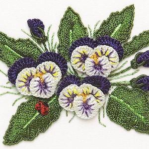 May include: Embroidered design of purple and white pansies with green leaves and buds. The pansies are stitched with a detailed, textured style.
