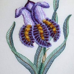 May include: A purple and yellow embroidered iris flower with green leaves. The flower is stitched with a variety of techniques, including satin stitch, French knots, and seed stitch.