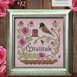 May include: Cross stitch pattern featuring a pink and green floral design with a small bird and the word "Gratitude". The pattern is titled "Heart Full of Gratitude" and is part of the "Songbird's Garden Series #12".