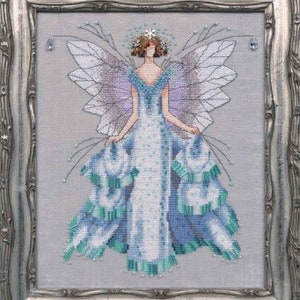 May include: A cross-stitch pattern of a fairy with blue and green wings and a white dress. The fairy is wearing a crown and has a delicate, ethereal look.