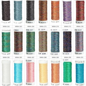 May include: A collection of twenty-one spools of metallic embroidery thread arranged in three rows. Each spool features a white plastic base and top, labeled with specific color codes ranging from MMA-262 to MMA-306, containing 50 meters of thread.