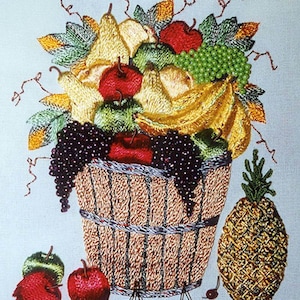 May include: A woven basket overflowing with a variety of fruit, including pears, apples, bananas, grapes, and a pineapple. The basket is sitting on a white background.