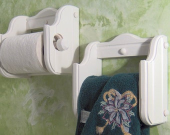 Könnte beinhalten: Weiße, wandmontierte Badezimmer-Ablage aus Holz mit einem Toilettenpapierhalter links und einem Handtuchhalter rechts.