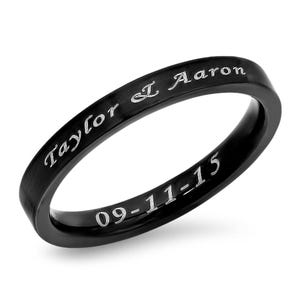 May include: Black ring with the inscription "Taylor & Aaron 09-11-15" in silver lettering.