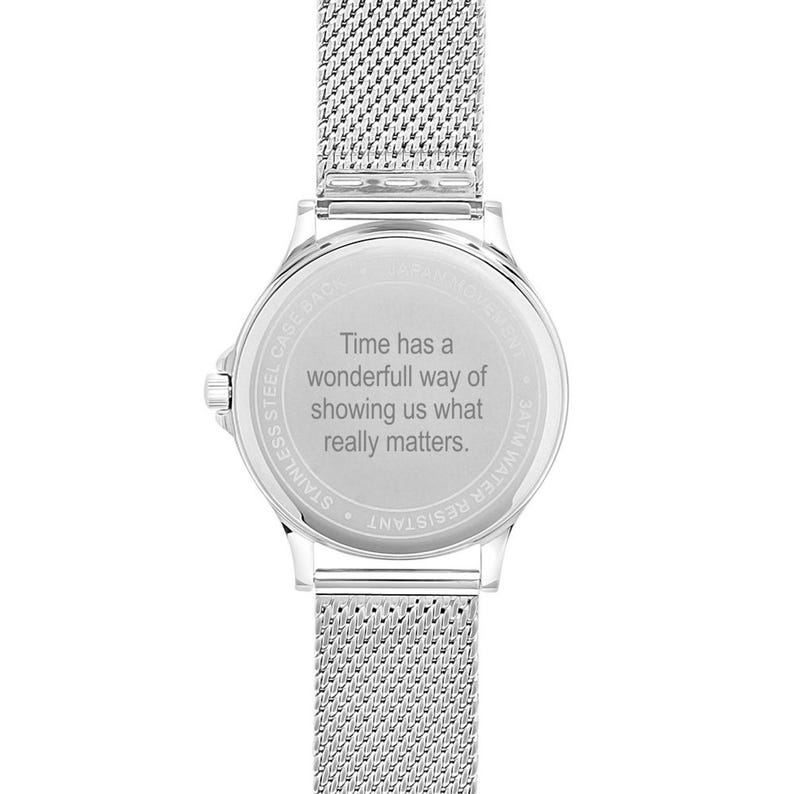 May include: A silver stainless steel watch with a mesh band. The watch face has the text "Time has a wonderful way of showing us what really matters."