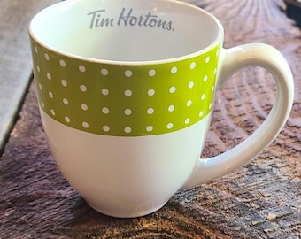 May include: White ceramic mug with a green polka dot band and the text "Tim Hortons."