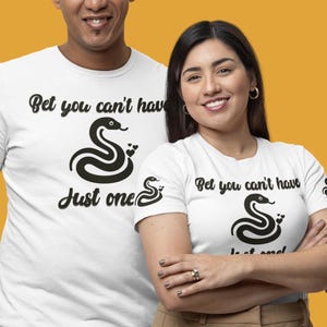 May include: Two white t-shirts with a black snake graphic and the text "Bet you can't have just one".