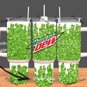 May include: A set of three insulated tumblers with white handles, lids, and straws. The tumblers feature a green glitter design with white drips and the Mountain Dew logo. Text includes "Want to make it a special gift?" and "Name Here."