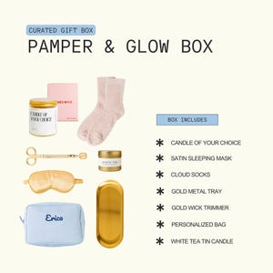The image is a curated gift box containing various beauty and personal care items, including a candle, a satin sleeping mask, a pair of gold socks, a gold metal tray, a gold wick trimmer, a personalized bag, and a white tea tin candle.