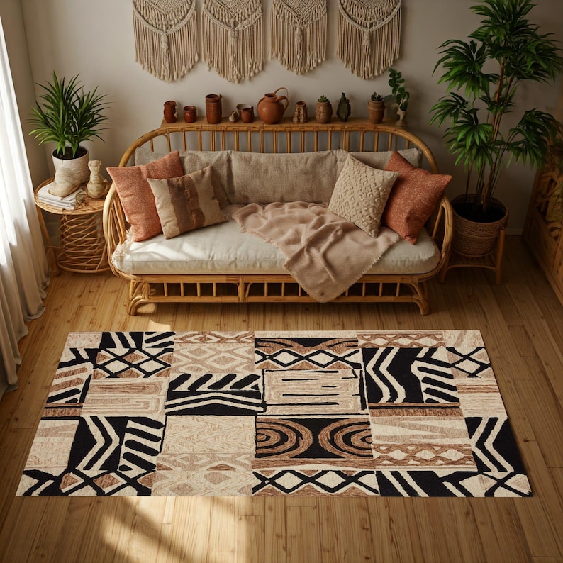 May include: A rectangular area rug with a patchwork design in black, beige, and brown geometric patterns. The rug is placed on a wooden floor in a living room setting, with a rattan sofa and decorative pillows.