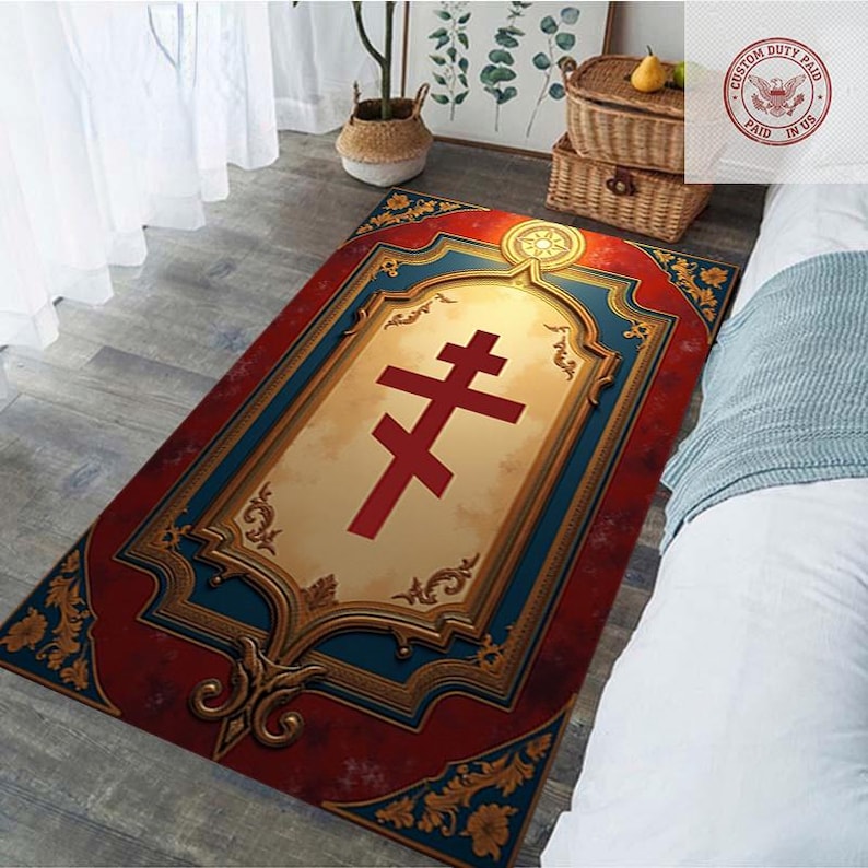 May include: Rectangular rug with a red and gold border, featuring a central design of a red cross on a cream background. The rug has a decorative, ornate frame with blue accents and floral patterns.