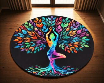 Op de afbeelding: Een ronde yogamat met een kleurrijk levensboomontwerp. De boom is gemaakt van bladeren in tinten groen, blauw, oranje en paars. Een persoon in een yogahouding wordt afgebeeld als de stam van de boom.