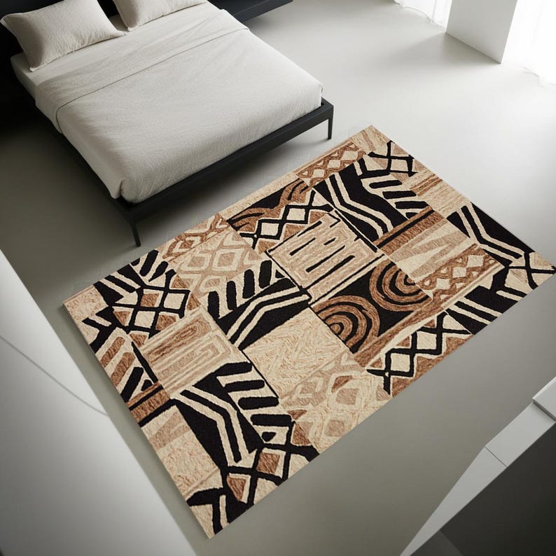 May include: A rectangular area rug with a geometric pattern in shades of black, brown, and beige. The rug features a patchwork design with various shapes and textures, suitable for a bedroom or living room.