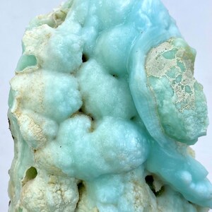 May include: A large, blue and white, geode with a bubbly, textured surface. The geode has a unique, organic shape and is a beautiful example of natural crystal formation.