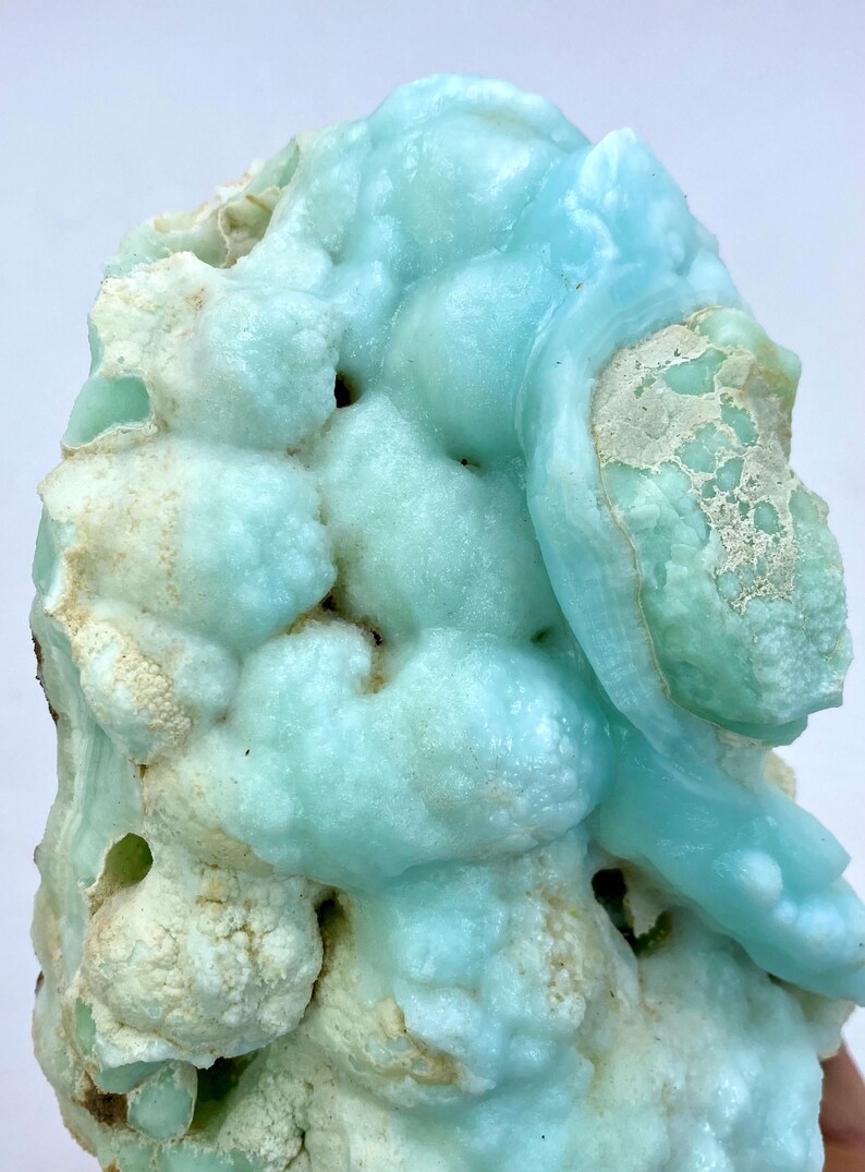 May include: A large, blue and white, geode with a bubbly, textured surface. The geode has a unique, organic shape and is a beautiful example of natural crystal formation.