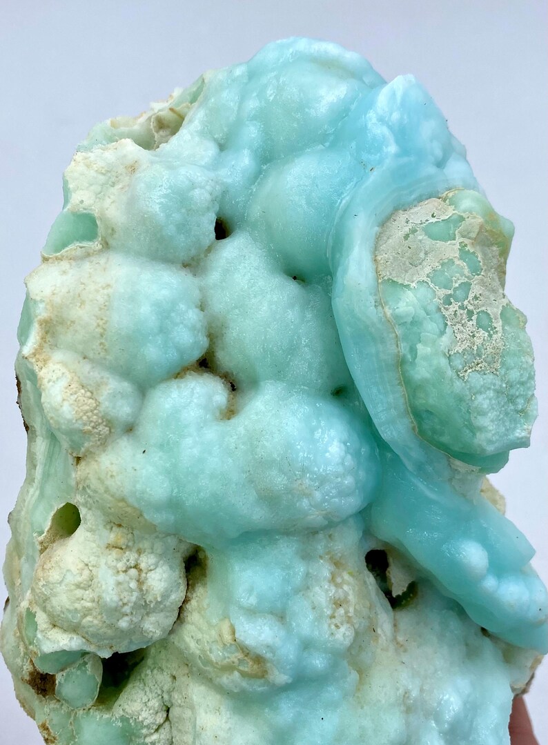 May include: A large, blue and white,  geode with a rough, textured surface. The geode has a unique, organic shape and is filled with small, white crystals.