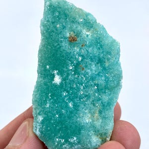 May include: A large, rough, teal green, natural, crystal specimen. The crystal has a textured surface and is translucent.