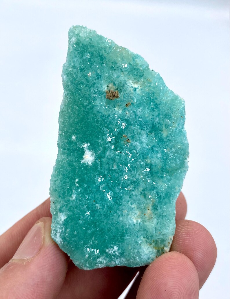 May include: A large, rough, teal green, natural, crystal specimen. The crystal has a textured surface and is translucent.