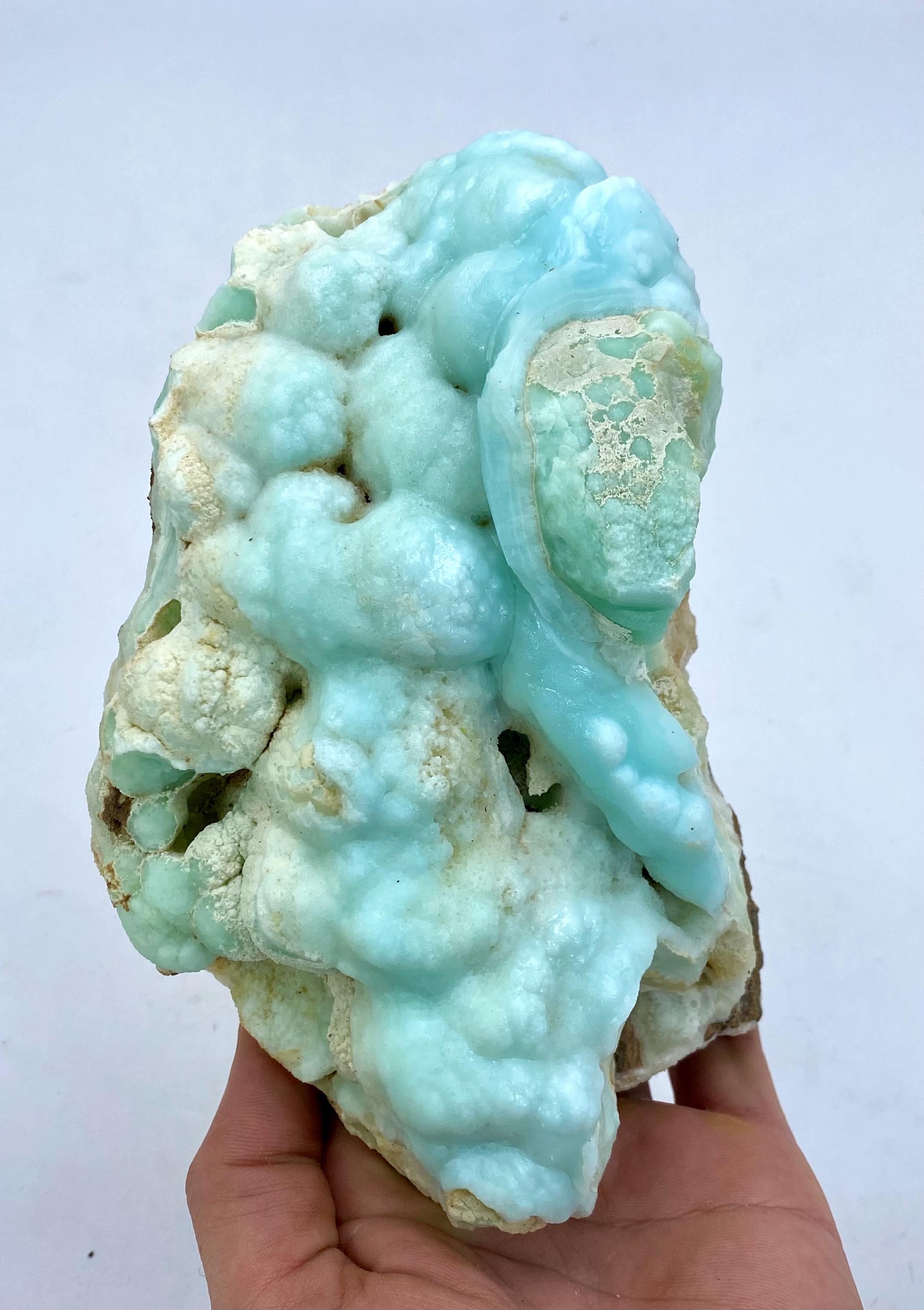 May include: A large, blue and white, geode with a unique, organic shape. The geode has a smooth, polished surface and is filled with small, white crystals.