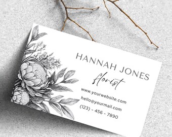 May include: Black and white business card with a floral design. The text on the card reads "Hannah Jones Florist", "www.yourwebsite.com", "hello@yourmail.com", and "(123) 456 - 7890".