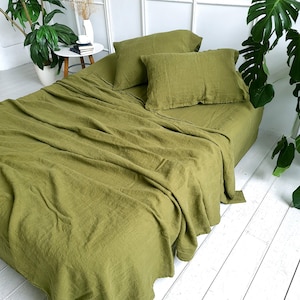 May include: A green linen bed sheet and pillowcase set. The bedding is made from 100% linen and is soft and breathable. The set includes a flat sheet, a fitted sheet, and two pillowcases.