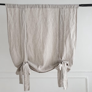 May include: A pair of beige linen curtains with a striped pattern, tied back with fabric ties.