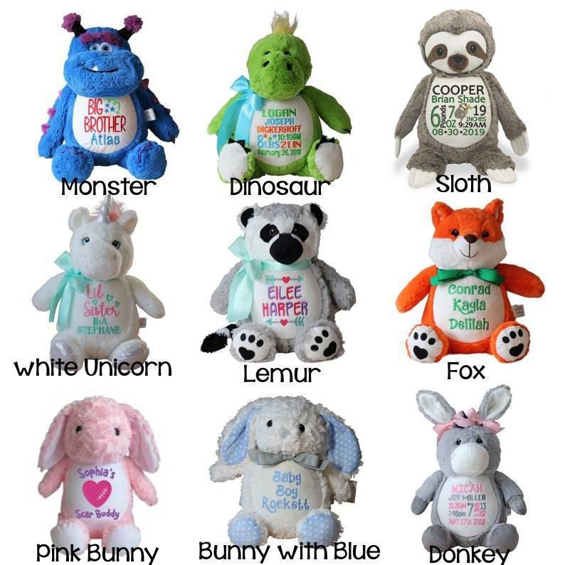 May include: A collection of nine plush stuffed animals, including a blue monster, green dinosaur, and gray sloth. Each animal has embroidered details and text, such as names and dates. The collection also includes a white unicorn, lemur, fox, pink bunny, blue bunny, and donkey.