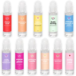 May include: Eleven clear glass roll-on perfume oil bottles, each 10 ml, featuring colorful labels with the brand name Chubby Star and scent names including cherry snob, juicy juicy mango, banana yum yum, daddy darling, midnight jasmine & amber, vanilla orchid & sandalwood, snow pixie, princess vanilla, marshmallow delight, strawberry shortcake, and only you.