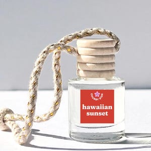 May include: A clear glass bottle with a red and white label that says "Chubby Star Hawaiian Sunset". The bottle is hanging from a white and gold rope.