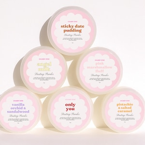 May include: A collection of six round containers of Chubby Star dusting powder. Each container has a pink and white label with a unique flavor name in a decorative font. Flavors include sticky date pudding, angel milk, pink marshmallow fluff, vanilla orchid & sandalwood, only you, and pistachio & salted caramel.