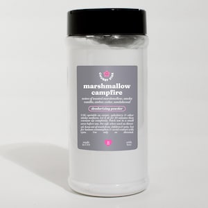 Könnte beinhalten: Ein weißes Plastikgefäß mit schwarzem Deckel, das ein weißes Pulver enthält. Das Etikett lautet "Chubby Star Marshmallow Campfire Deodorizing Powder" und listet Noten von geröstetem Marshmallow, rauchiger Vanille, Bernstein, Zeder und Sandelholz auf. Das Etikett enthält auch Gebrauchsanweisungen und gibt an "Made in USA" und "mit Liebe".