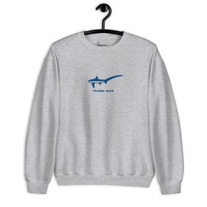 May include: A gray sweatshirt with a blue thresher shark graphic and the text "Thresher Shark" printed on the front.